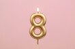 Birthday candle burning on pink background, number 8