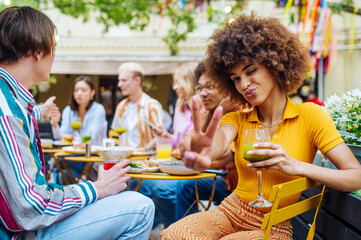 Multiracial young people together meeting and having party in a restaurant - Group of friends with mixed races having fun celebrating in a bar- Friendship and lifestyle concepts