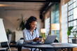 © bnenin - Smiling businesswoman using a mobile phone while working online.