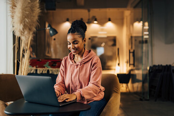 Wall Mural - Casual African businesswoman working over the laptop.