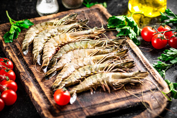 Sticker - Raw shrimp on a cutting board with parsley and tomatoes. 