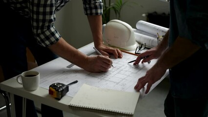 Wall Mural - Two cropped architects discussing floor plan at table in office. Design of the house. Engineer. Tools for drawing. Creating a drawing.