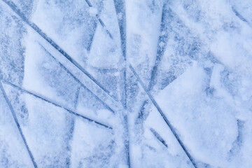 Empty ice rink with skate marks after the session outdoor. skating ice rink texture covered with snow in daylight. Close up of blue ice rink floor, copy space