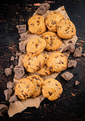 Wall Mural - Cookies with pieces of milk chocolate on the table. 