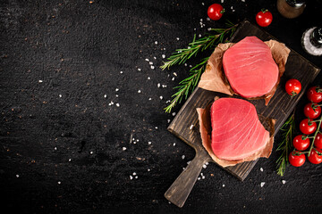 Wall Mural - Raw tuna on a cutting board with tomatoes and rosemary. 