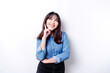 © Reezky - A thoughtful young woman dressed in blue shirt while looking aside, isolated by white background