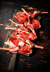 Poster - Sliced raw rack lamb. Against a dark background.