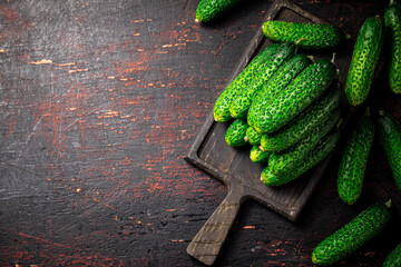 Sticker - Fresh cucumbers on a wooden cutting board. 