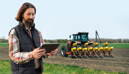 Autocollant - Farmer with a digital tablet on the background of an agricultural tractor with seeding machine
