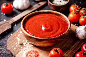 Canvas Print - Tomato sauce on a wooden cutting board with garlic and spices.