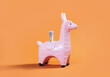 coin money bank. Pink zine type toy alpaca llama with dollar note on orange background close up. Creative and fun funky concept of savings or loan for travel or education. copy space