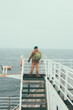 Back view of the tourist man with backpack aboard a ferry looking around. Male enjoying the view before the shipping.