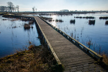 Wooden Walkbridge For Pedestrians Across A Shallow Lake, Partly Coverd With Ice Near Dwingelo, The Netherlands