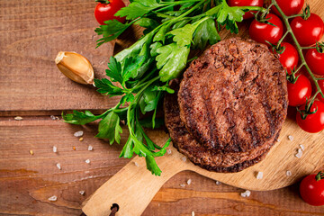 Poster - Burger grill on a cutting board with greens and tomatoes. 