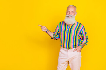 Canvas Print - Photo of positive satisfied aged person indicate finger empty space promo isolated on yellow color background