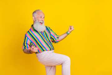 Sticker - Photo of lucky positive guy dressed striped shirt yelling looking empty space rising fists isolated yellow color background