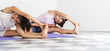 © Pajaros Volando - Two women practicing yoga with stitching in Parivrtta Janu Sirsasana. Selective focus with copy space. Long landscape format