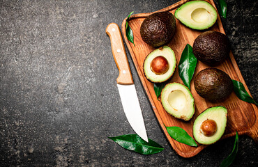 Wall Mural - Fresh avocado with foliage on a cutting board.