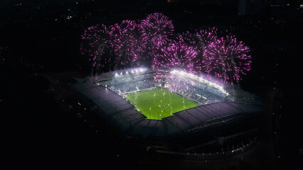 Aerial Establishing Shot of a Whole Stadium with Soccer Final Match Starting. Teams Play, Crowd of Fans Cheer, Fireworks Launched From Top of The Arena. Football Tournament, Cup TV Broadcast.