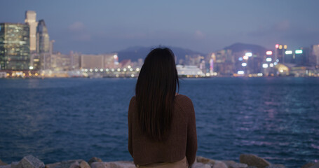 Poster - Woman look at the city of Hong Kong at night