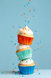 Stack of cupcakes with falling sprinkles