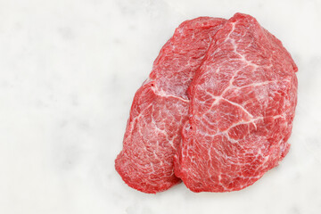 Wall Mural - Two slices of raw beef fillet steaks on white marble background, top view. Wagyu fillet with copy space