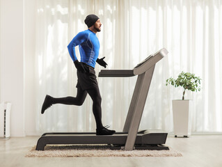 Sticker - Profile shot of a man running on a treadmill indoors