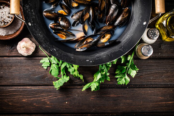 Canvas Print - Mussels in a saucepan with parsley and spices. 