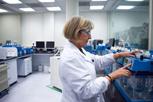 Smiling Mature Scientist Woman Wearing Lab Coat And Glasses Working In Production Research Laboratory For The Diagnostic And Analysis Of Diseases Happy To Find A Health Treatment At Modern Work Center