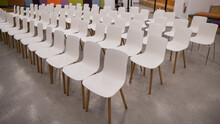 Empty White Plastic Chairs In A Conference Room. 