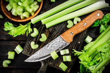 Wall Mural - Sliced fresh celery. On a dark wooden background.