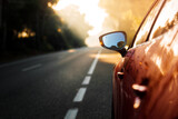 Red car on the road during the sunset