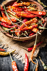 Canvas Print - Pods of dried chili peppers in a wooden plate on a napkin. 