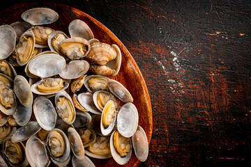 Sticker - A wooden plate full of fresh vongole. 