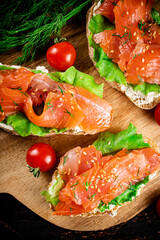 Poster - Sandwich with pieces of salmon on a cutting board. 