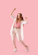 © Pixel-Shot - Young woman in headphones dancing on pink background
