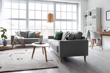 Interior of modern living room with grey sofas, window and shelving unit