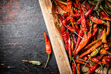 Wall Mural - Dried chili peppers in a wooden tray. 