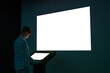 Woman looking at white blank interactive touchscreen display of electronic multimedia kiosk in dark room of technology exhibition. Large white display on wall. Mock up, copyspace and template concept