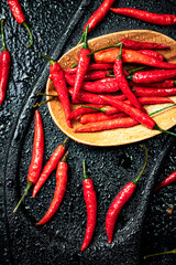 Canvas Print - Pods of hot chili peppers on a cutting board.