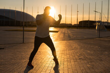 A Man Trains Boxing At Sunset Outdoors.