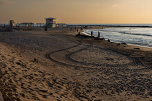 Haifa, Israel - January 20, 2023, Dado Beach At Sunset. People Walk Along The Beach. Lifeguard Booths.