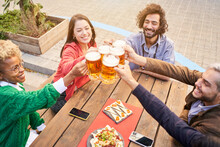 Group Of Attractive Young People Toasting With A Beer. Happy Friends Having Fun Outdoors. High Quality Photo