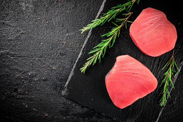 Canvas Print - Raw tuna on a stone board with rosemary. 