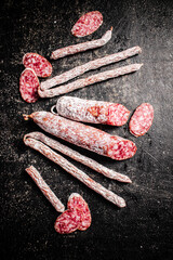 Poster - Sticks of salami sausage on the table. 