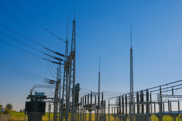  Electricity and energy.Power station in the rays of the sun on a blue sky background.Energy equipment.High tension power. electricity line. Power lines on blue sky background.