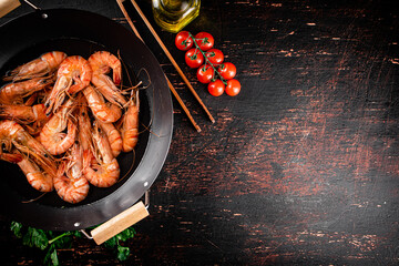 Wall Mural - Cooked shrimp in a saucepan with parsley and tomatoes. 