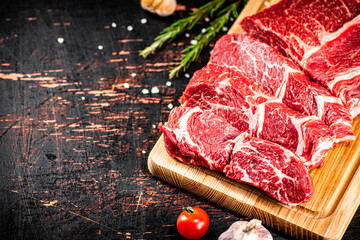 Sticker - Raw beef on a wooden cutting board with rosemary.