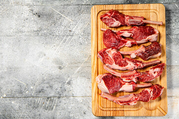 Sticker - Cut into pieces of raw rack lamb on a cutting board. 