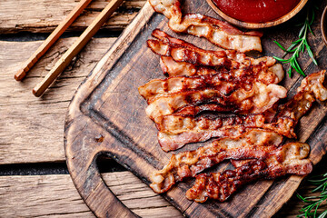 Canvas Print - Pieces of fried bacon with tomato sauce.